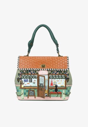 Torebka zaprojektowana jako fasada sklepu z ciastami z dachówką z daszkiem, pasiastymi markizami, otwartymi drzwiami, tablicą z menu i czarnym kotem siedzącym na ławce.