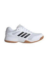 Zapatilla deportiva blanca hecha de malla y goma, presenta tres rayas negras, una superficie texturizada y una suela de goma para tracción.