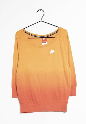 Nike trui met lange mouwen met een oranje naar rood verlopende kleurverloop, ronde hals en klein wit Nike-logo op de borst, hangend aan een zwarte hanger.