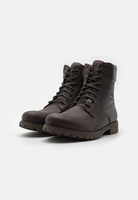 Botas de senderismo de cuero marrón con acabado texturizado, puntera redonda, ojales reforzados y suela de goma resistente. Soporte alto para el tobillo con detalles de costura.