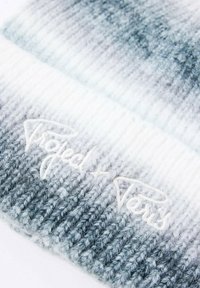 Beanie grigio a gradiente, realizzato in maglia, con texture a coste e logo ricamato bianco. Misto lana morbido, con un design ombré che va dal chiaro allo scuro.