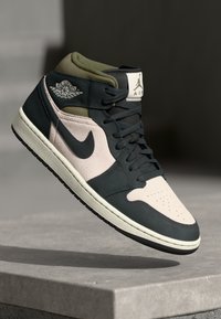 Visoke tenisice s tamnoplavom kožom, ružičastim panelima od antilopa, maslinasto zelenim akcentima, Air Jordan brendingom i zrnatom crnom gumenom potplatom.
