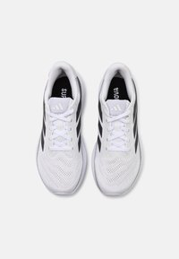 Paire de chaussures de course blanches avec des bandes latérales noires, des lacets blancs et des colliers rembourrés, vue de dessus sur un fond blanc.