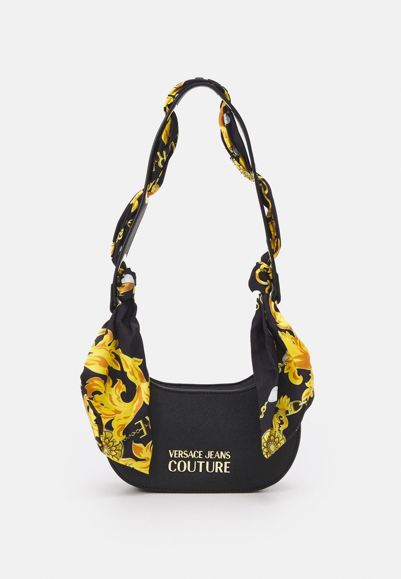 Black handbag featuring a floral patterned strap in yellow and black; includes "Versace Jeans Couture" logo on the front.