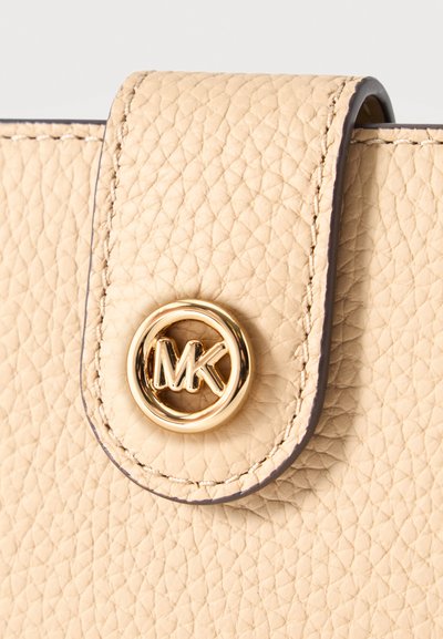 Rabat en cuir beige texturé pour sac à main avec couture apparente et fermeture par bouton rond doré avec logo MK.