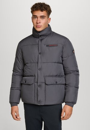 Dunkelgraue Pufferjacke mit hohem Kragen, Druckknöpfen und zwei Vorderaschen. Das Material ist glatt und hat ein gestepptes Design.