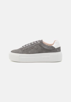 Low-top grey suede sneaker with white chunky sole and heel collar, featuring grey laces and subtle logo detailing on side.