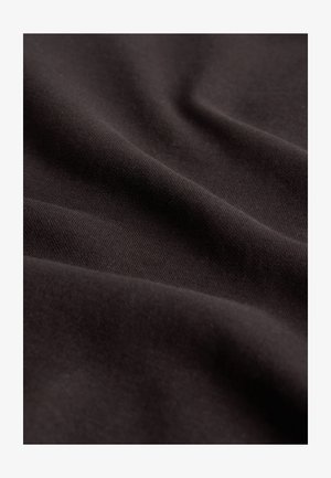 Mustast kangast, millel on sile tekstuur, veidi peegeldav pind ja õrn venivus, mis langeb õrnadesse voldikutesse.