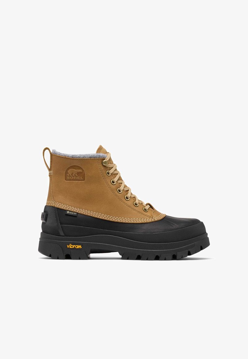 Botte d'cheville étanche avec tige en cuir beige, semelle en caoutchouc noire, doublure en polaire grise et logo Vibram jaune. Dotée d'œillets métalliques.
