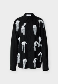 Μαύρο πουκάμισο με κουμπιά και άσπρες δαντέλες που μοιάζουν με φιόγκους, με μυτερό γιακά και μακριά μανίκια. Λείο ύφασμα.