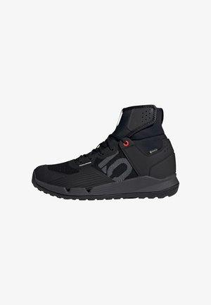 Black high-top trail shoes featuring a mesh upper, contrasting textures, rubber sole, and red accents on the eyelets and branding.