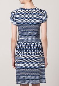 Sukienka z krótkim rękawem z geometrycznym wzorem w odcieniach niebieskiego, białego i czarnego. Dopasowany krój z gładką teksturą materiału.