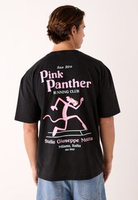 Črna bombažna majica s prikupnim rožnatim motivom Pink Panther, ki teče, z napisom "San Siro Pink Panther Running Club."