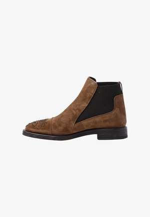 Bottines Chelsea en daim marron avec un panneau élastique noir, bout pointu et détails cloutés à l'avant. Talon bas et tige texturée.
