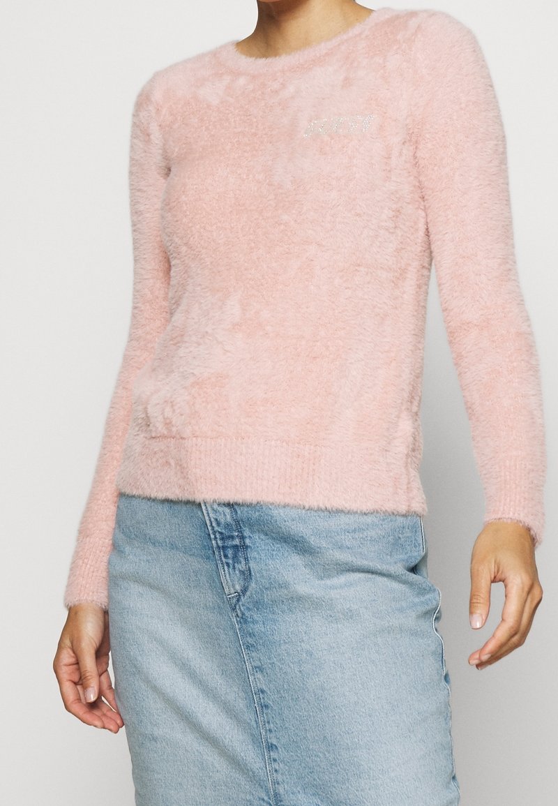 Rosa, fluffig tröja med rund halsringning och långa ärmar, med en subtil logotypaccent. Mjuk textur och figurnära design.