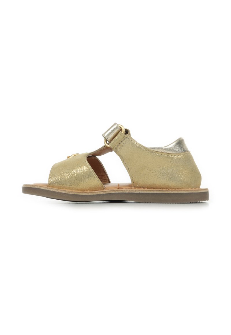 Sandalia de cuero metálico dorado con punta abierta, correa ajustable y suela plana. Presenta un brillo sutil y un diseño simple y minimalista.