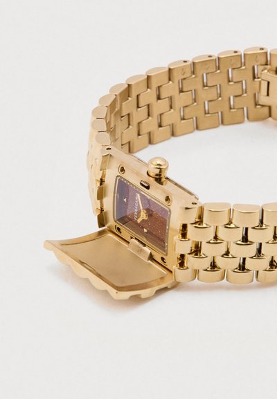 Náramkové hodinky v zlatej farbe s obdĺžnikovým ciferníkom, vzorovaným remienkom a pántovým krytom. Majú lesklý kovový povrch a tmavý ciferník so zlatými akcentmi.