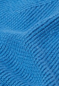 Blauw gestructureerd stof met een geribd patroon, met een zachte, donzige uitstraling en variaties in diepte en weefsel.