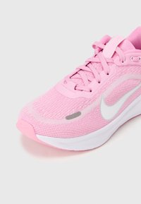 Roze hardloopschoen met ademend mesh-bovenwerk, witte zool, platte veters en een reflecterend zilver Swoosh-logo aan de zijkant.