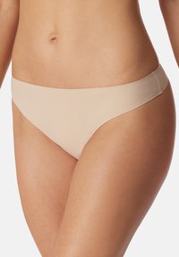 Bikini pendek berwarna nude terbuat dari kain yang halus dan elastis dengan desain tanpa jahitan, dilengkapi dengan pinggang lebar dan cakupan minimal.