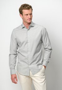 Gestreifte Button-Up-Hemd aus grauem und weißem Stoff mit langen Ärmeln, ausgestattet mit einem Kentkragen und Knopfleiste, kombiniert mit hellen Hosen.