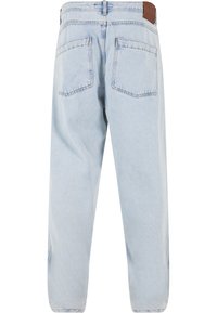Jeans din denim de culoare albastru deschis, cu talie înaltă, două buzunare pe spate și o eticheta din piele maro la talie. Croială dreaptă și cusături minime.