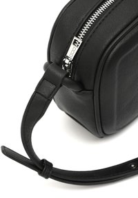 Svart läder crossbody-väska med rektangulär form, silverfärgad dragkedja och en platt rem. Texturerad yta med subtila sömmar.
