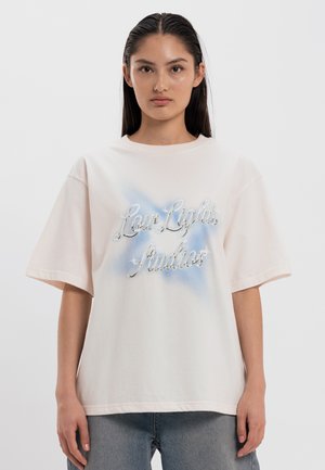 Crèmekleurig oversized t-shirt met korte mouwen, met een blauw-witte gradient en metallic lettering "Low Lights Studios" in het midden.