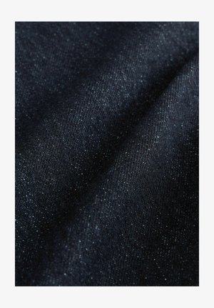 Donker denimstof met een zachte textuur, voorzien van een lichte glans en een subtiel ribpatroon. Bevat vaag vlekjes in een lichtere kleur.