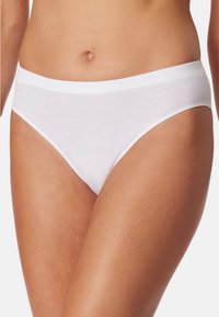 Culotte blanche en coton avec une texture lisse et côtelée, dotée d'une large ceinture élastique. Design classique à taille basse offrant une couverture minimale.
