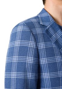 Niebieska marynarka w kratę z teksturowanej tkaniny. Posiada białe linie tworzące wzór w kratkę, usztywnione ramiona oraz klapę z nacięciem.