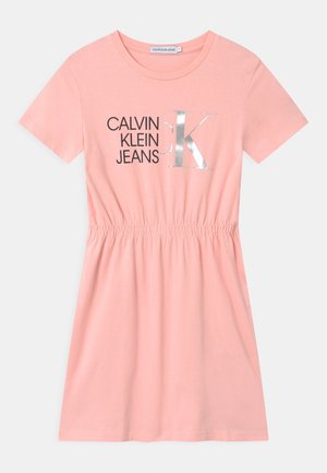 Różowa sukienka z krótkim rękawem z bawełny, z marszczeniem w talii, z czarnym napisem "CALVIN KLEIN JEANS" oraz srebrnym "K" z przodu.