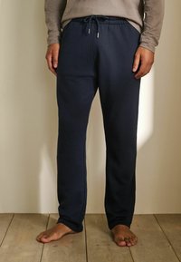 Pantaloni sportivi blu navy in tessuto morbido, con vita elastica e coulisse, gambe dritte e tasche laterali.