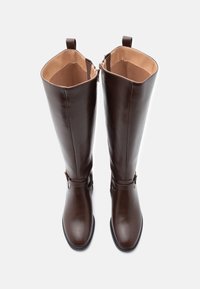 Rudi odos iki kelių siekiantys batai su lygiu paviršiumi, turi užtrauktuką ir dirželio akcentus. Vidus išklotas smėlio spalvos audiniu.