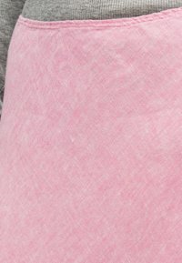 Ροζ ύφασμα με ελαφρώς υφή επιφάνεια, περιβαλλόμενο από λείο γκρι ύφασμα. Το σχέδιο έχει απλό, λιτό στιλ.