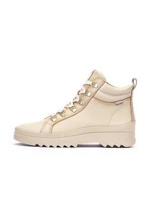 Light beige high-top sneakers made of leather, featuring gold hardware, a textured upper, and a rugged outsole with a zigzag pattern.