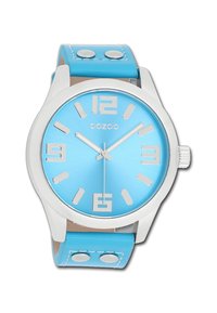 Montre bleu aquatique avec un cadran métallique brossé, des marqueurs d'heure argentés et un bracelet en simili cuir. Comprend deux boutons métalliques sur le bracelet.