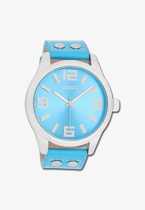 Montre bleu aquatique avec un cadran métallique brossé, des marqueurs d'heure argentés et un bracelet en simili cuir. Comprend deux boutons métalliques sur le bracelet.