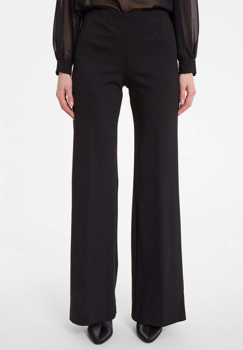 Zwarte wijde broek met een gestructureerde afwerking en subtiele glans. Elastische tailleband, vloeiende uitstraling en lange silhouette voor een comfortabele pasvorm.