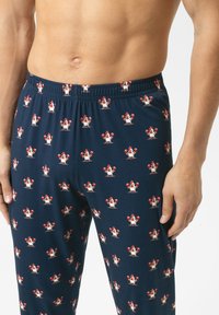 Marineblauwe katoenen pyjamabroek met een herhalend kippenpatroon in rood en wit. Elastische tailleband en een relaxte pasvorm.