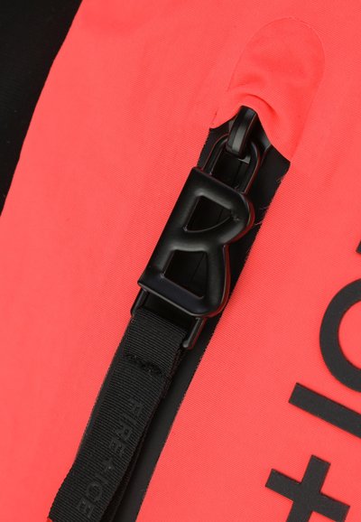 Koralfarbener Stoffrucksack mit einem großen schwarzen Reißverschluss, ausgestattet mit einem verstellbaren schwarzen Tragegurt und auffälligem Logo-Druck. Glatte Textur, langlebiges Design.