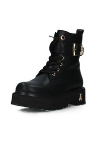 Stivaletti alla caviglia in pelle nera con fibbie e occhielli dorati, caratterizzati da una suola piatta spessa e una finitura strutturata.