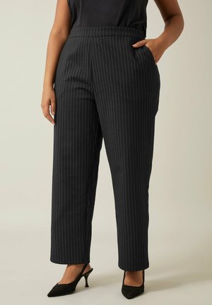 Zwarte pinstripe broek met een getailleerde pasvorm, hoge taille, zijzakken en een soepele textuur, gecombineerd met puntige zwarte hakschoenen.