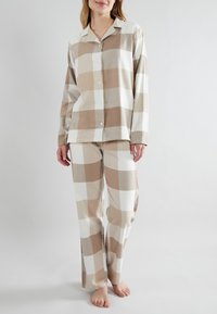 Beige and white plaid pajama set featuring a button-up shirt with long sleeves and matching pants with a relaxed fit. Soft fabric texture.