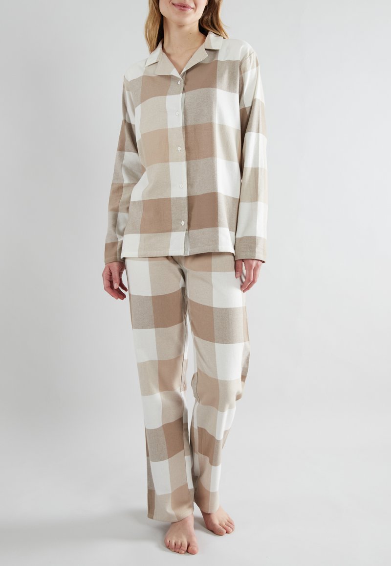 Beige and white plaid pajama set featuring a button-up shirt with long sleeves and matching pants with a relaxed fit. Soft fabric texture.