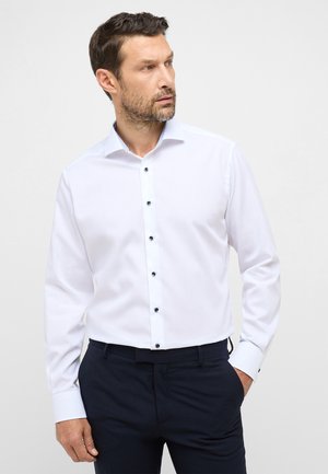 Weißes Langarmhemd mit schwarzen Knöpfen, taillierter Schnitt, minimalistisches Design, glatte Textur und kontrastierender gemusterter Kragen.
