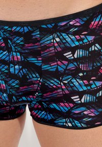Boxer neri con un motivo geometrico colorato in blu, rosa e bianco, con una cintura elastica nera con logo.
