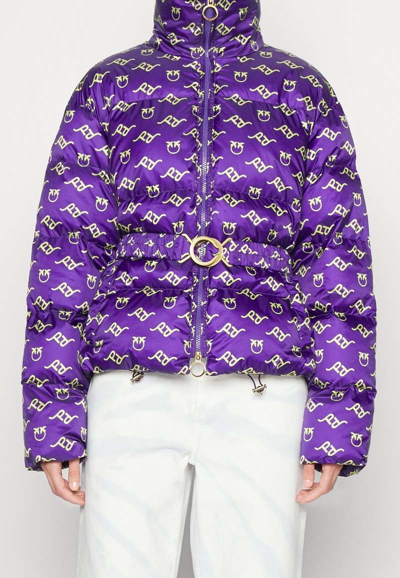 Doudoune violette avec un motif répétitif de logos jaunes, col montant, fermeture éclair à l'avant, taille cintrée avec un anneau doré et cordons de serrage ajustables.