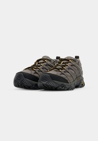Grijze wandelschoenen met zwarte buitenzool, ademend mesh bovenwerk, gele accenten en een robuust ontwerp. Voorzien van duurzame veters en een gestructureerde zool.