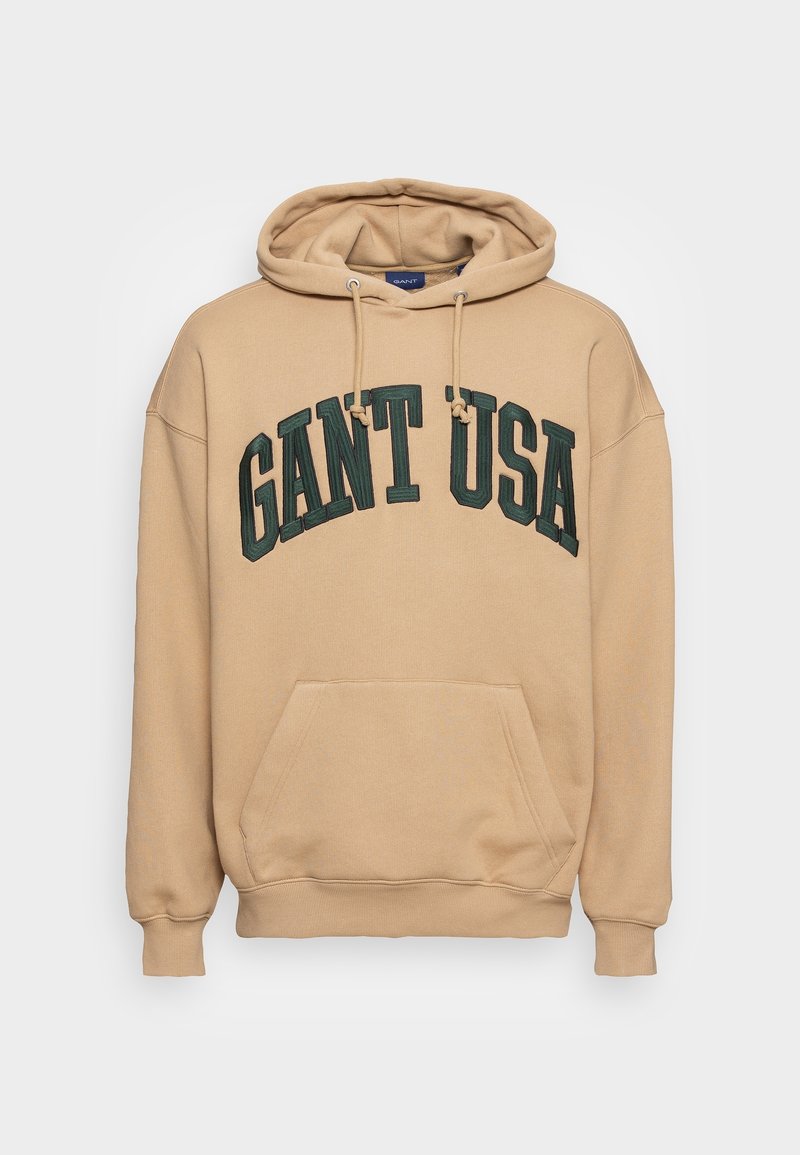 Beżowa bluza z kapturem, z przednią kieszenią i sznurkami, z dużym, ciemnozielonym napisem "GANT USA" na klatce piersiowej.